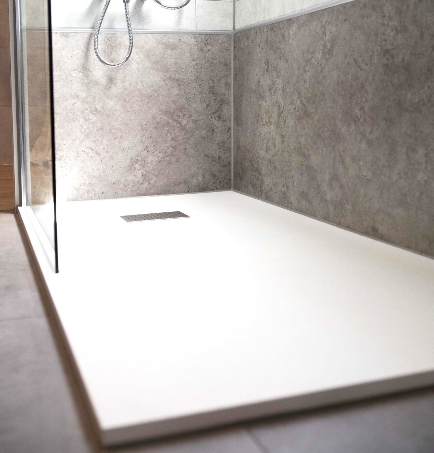 Novadusch Referenz bodengleiche Dusche mit grauen Wandpaneelen in Betonoptik und Glasabtrennung