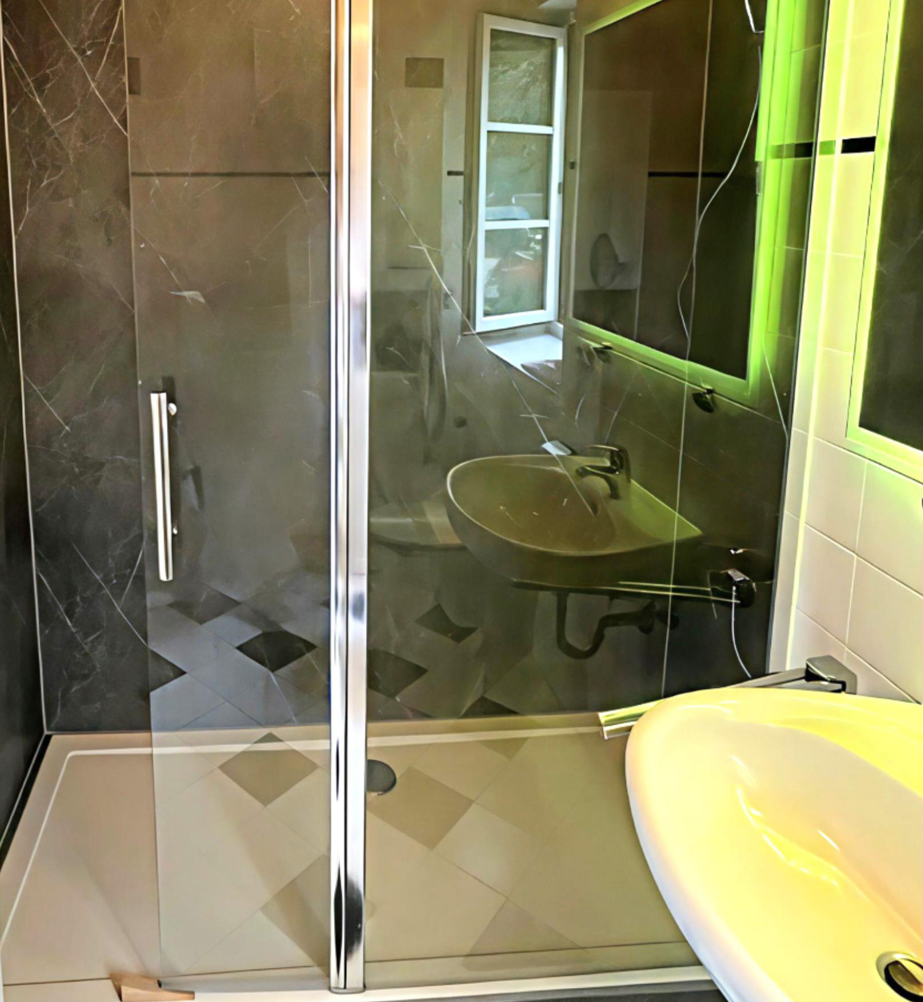Barrierearme Dusche mit schwarzer Marmoroptik und Glasabtrennung