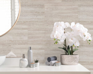 Modernes Badezimmer mit heller Wandverkleidung in Natursteinoptik, dekoriert mit weißen Orchideen und minimalistischen Accessoires.