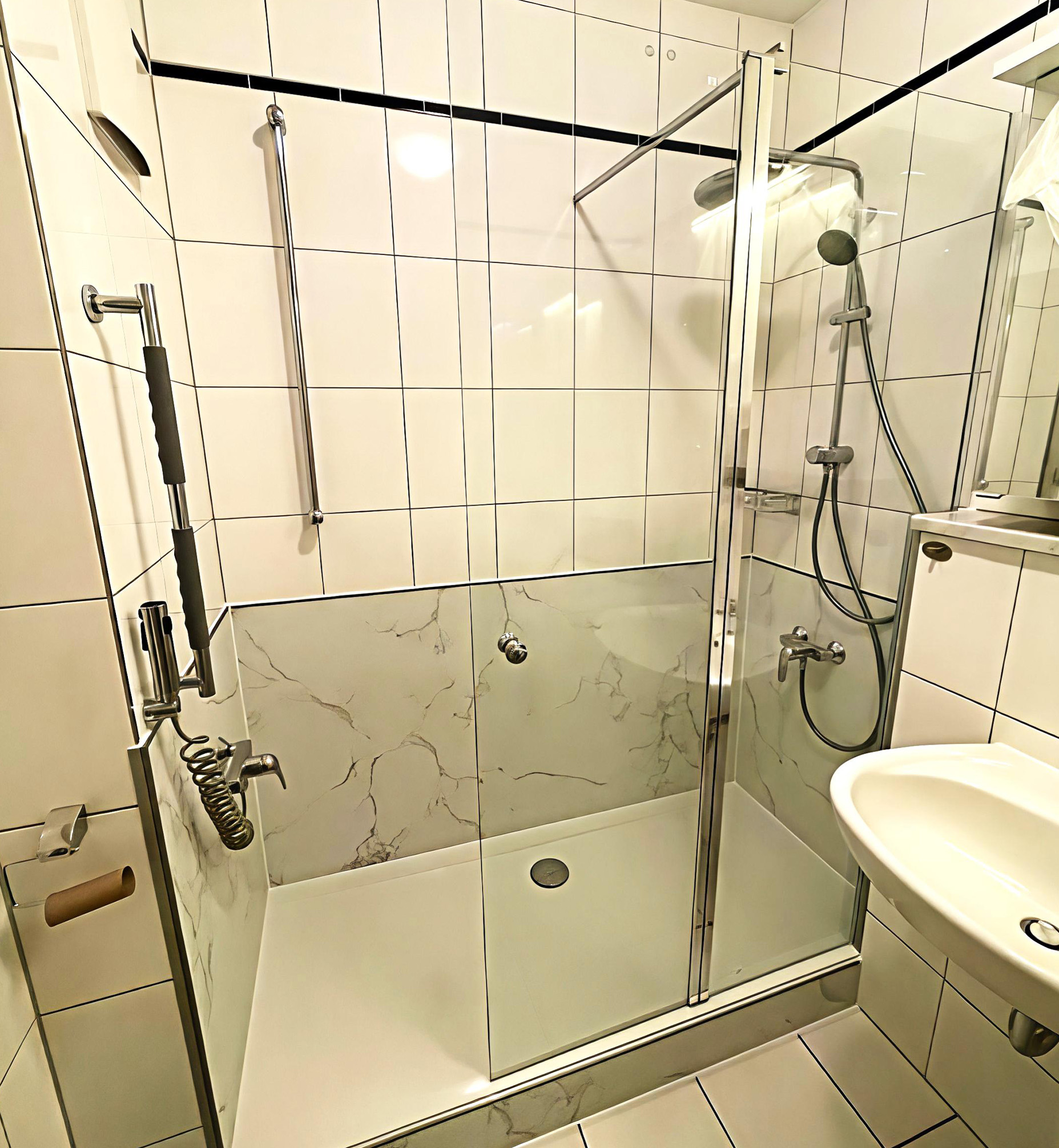Barrierearme Dusche mit weißen Fliesen, Marmoroptik und Glasfront
